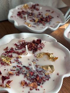 two white bowls filled with food on top of a wooden table