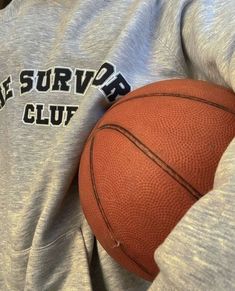 a basketball sitting on top of a person's back with the words the survivor club written on it