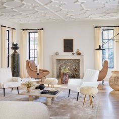 a living room filled with white furniture and lots of windows