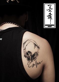 a man with a skull tattoo on his shoulder