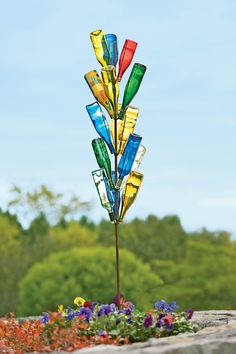 a multi colored glass wind chime in the shape of a tree on top of a pole