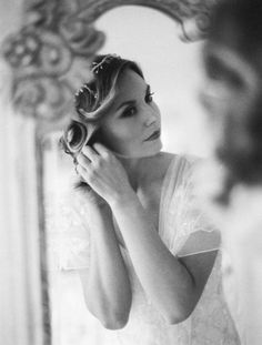 a woman is brushing her hair in front of a mirror