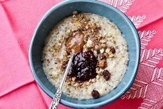 a blue bowl filled with oatmeal topped with raisins and cranberries