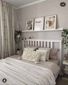 a white bed sitting under two pictures on the wall