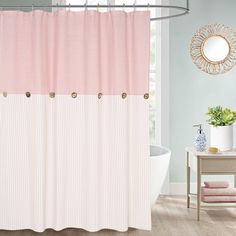 a bathroom with a pink shower curtain and white tub