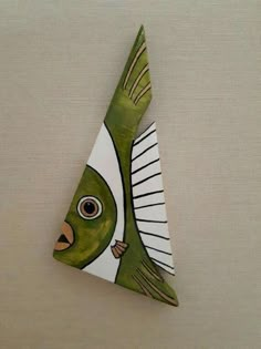 a green and white ceramic fish on a wall