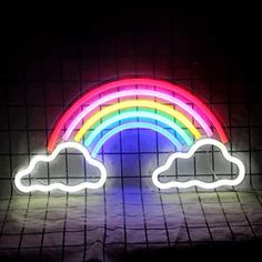 a neon sign with a rainbow in the middle and clouds on it's side