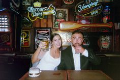 a man and woman sitting at a bar drinking beer