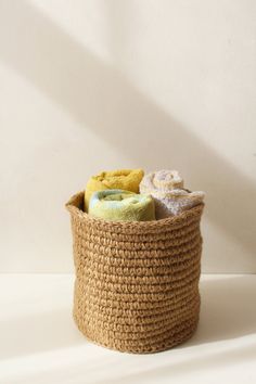 a basket filled with towels on top of a white table