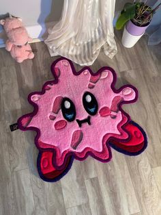 a pink rug with black eyes on the floor