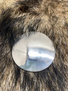 an animal's fur with a metal button on it