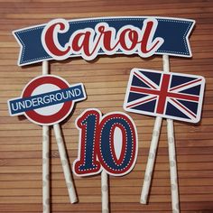 cake toppers with the number 10 and british flags on them are displayed in front of a wooden table