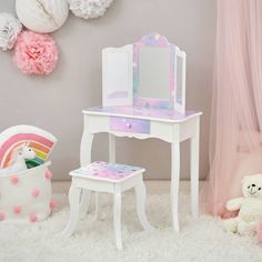 a toy vanity with a mirror, stool and teddy bear sitting on the floor next to it