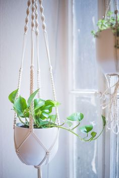 the macrame planter is hanging in front of a window