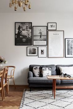 a living room filled with furniture and pictures on the wall above it's coffee table