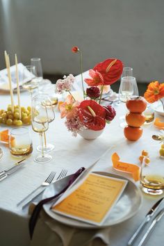 the table is set with flowers and wine glasses