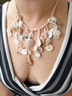 a close up of a woman wearing a necklace with many buttons on the back of her chest