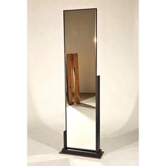 a large mirror sitting on top of a wooden stand