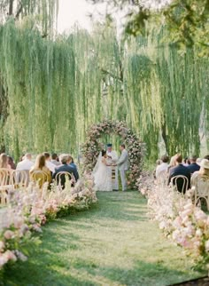 a couple getting married under a willow tree