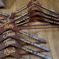 wooden hangers with names and dates on them sitting on a wood floor in the shape of a tree