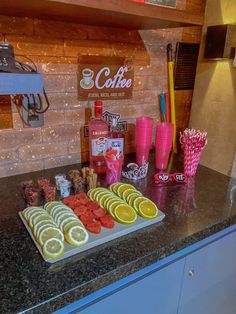 a counter topped with trays of lemon slices and strawberries on top of it