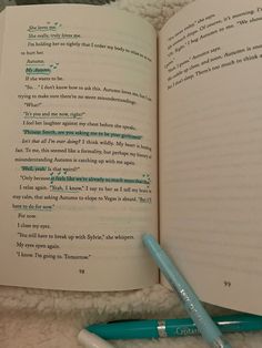 an open book with writing on it next to a blue ballpoint pen and white towel