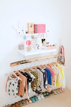 a rack with shoes and clothing on it in front of a wall mounted bookshelf