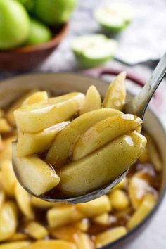 a spoon full of apple slices with caramel sauce