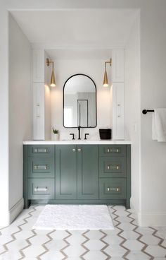 a bathroom with green cabinets and a white rug on the floor in front of it