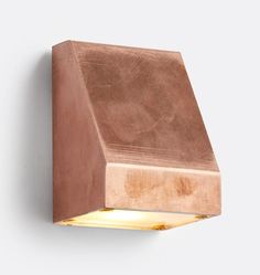 a light that is on the side of a wall with a wooden block attached to it