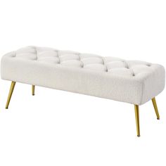 a white bench with gold legs and a buttoned up seat cushion on the back