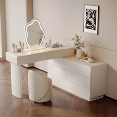 a white dressing table with a mirror and stool in a room that has hardwood floors