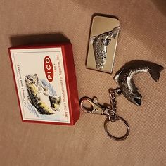 a fish keychain sitting on top of a table next to a matchbox