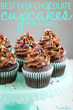 cupcakes with chocolate frosting and sprinkles on a cake plate