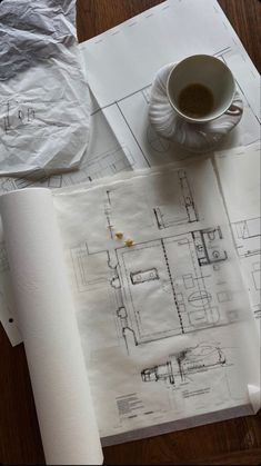 a cup of coffee sitting on top of a table next to some papers and paper