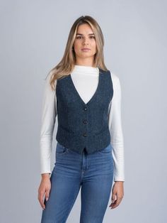 A must for Ladies who love trends, shape and function in their clothing. This Irish designed  piece is trendy yet functional. This  garment is shaped to combine traditional tailoring with a contemporary edge. This tweed waistcoat is a visually stunning  key piece  that is made for any occasion. The herringbone blue tweed has flecks of color that give it a unique oceanic feel. Wear with denim for a more  casual look or with a skirt for a more formal occasion.   The Celtic Tweed ladies collection of tweed waistcoats and vests are our interpretation on timeless Irish design. Our tweed waistcoats offer our wearers a fluid and tailored silhouette that is perfect for creating a classic yet contemporary look. Our ladies waistcoats are unique handmade from tweeds and linen resulting in flattering Casual Tweed Vest For Winter, Fitted Herringbone Vest For Fall, Fitted Tweed Vest For Winter, Fitted Tweed Vest For Work, Tweed Vest For Workwear In Fall, Fitted Casual Tweed Outerwear, Fitted Blue Tweed Outerwear, Casual Fitted Tweed Outerwear, Fitted Tweed Vest With Herringbone Pattern