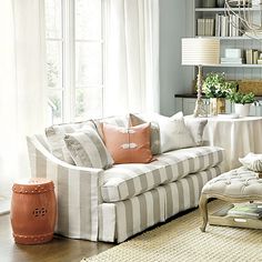 a living room filled with furniture and lots of white curtains on the window sill