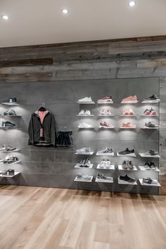 a display case filled with lots of shoes and clothing on shelves next to a wooden floor