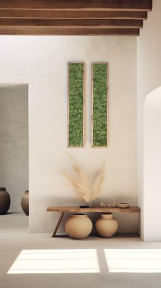 two vases sitting next to each other on top of a wooden table in a room