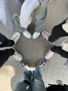 several people standing in a circle with their feet up