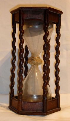 an old fashioned wooden hourglass with sand running through it