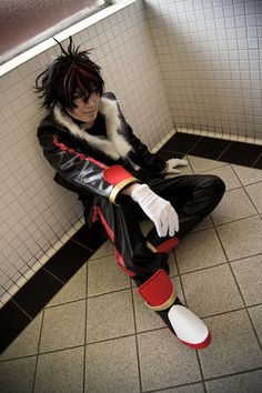 a person sitting on the ground in a room with tile walls and flooring,