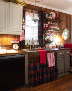 the kitchen is decorated for christmas with red and black plaid towels hanging from the window