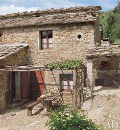 an old stone house with vines growing on the roof