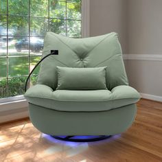 a green chair sitting on top of a hard wood floor in front of a window