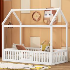 a white dollhouse bed with a cat on the top and a clock above it