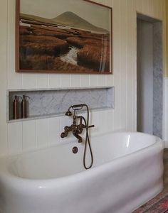 a bathroom with a large tub and painting on the wall