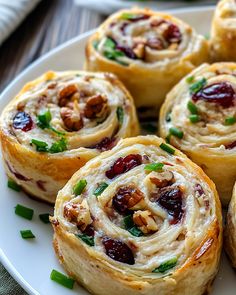 a white plate topped with rolls covered in cranberry sauce and pecanse