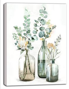 three glass vases with flowers and greenery in them