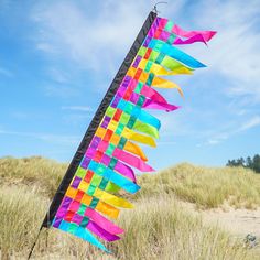 a colorful kite sticking out of the sand